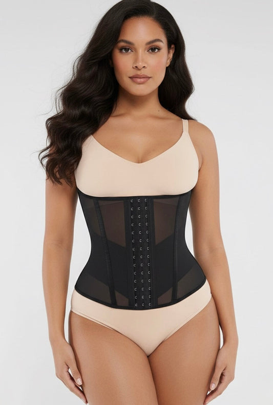 Woman wearing a black waist trainer over a beige top and underwear set on a white background