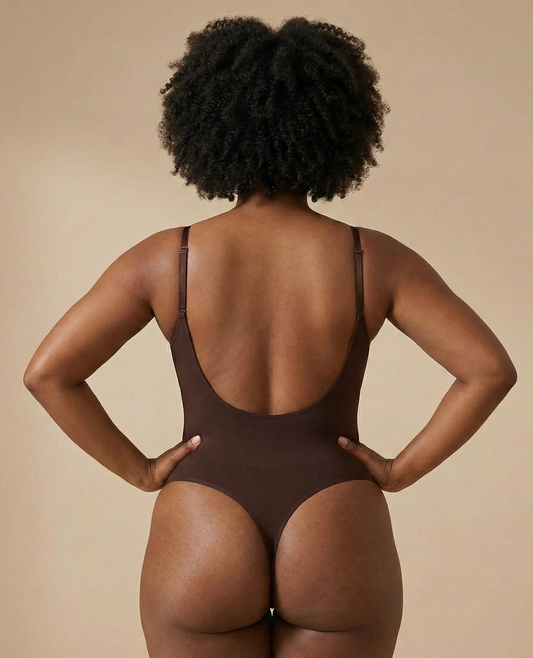 Person wearing a brown bodysuit against a beige background